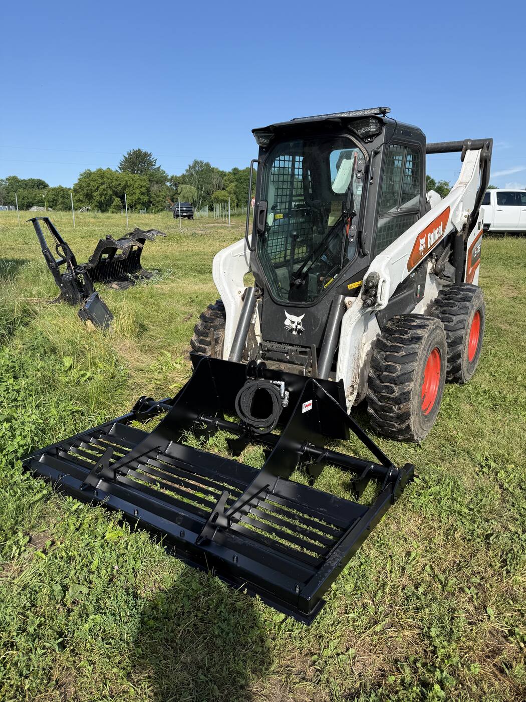 Bobcat skid loader with land leveler attachment — Revisions Unlimited equipment