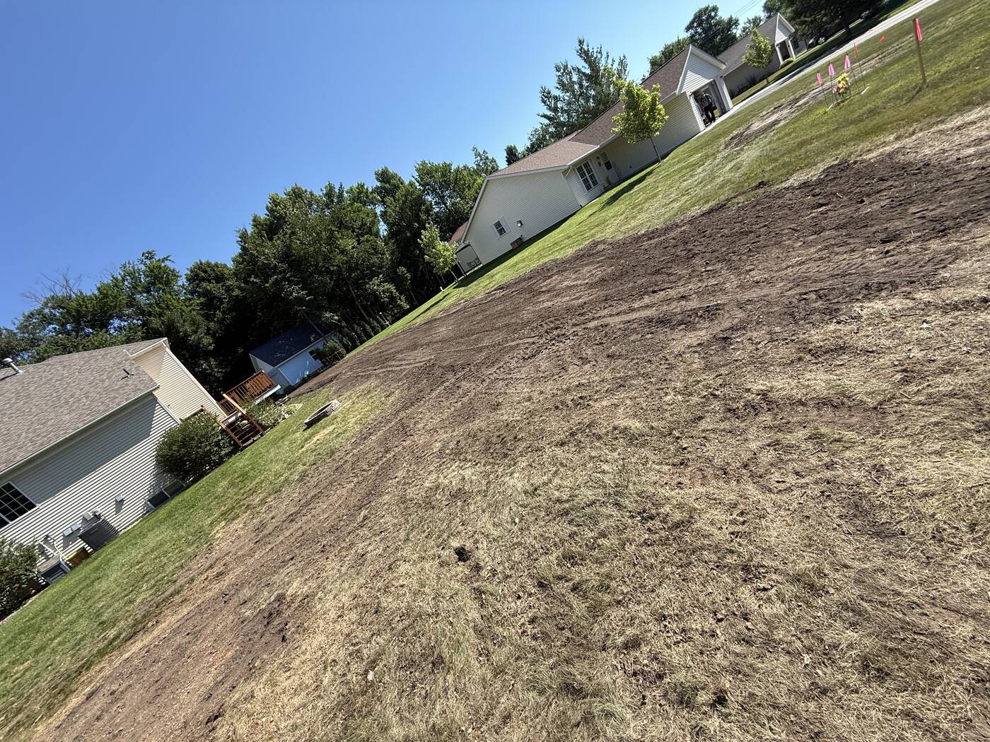 Same yard finish-graded with screened black dirt, blended into the lawn and ready for seed
